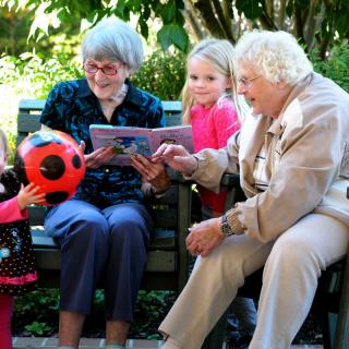 A joyful family gathering featuring multiple generations enjoying time together outdoors.