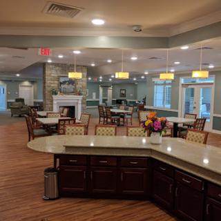 A spacious and inviting dining area featuring modern furnishings and bright lighting.