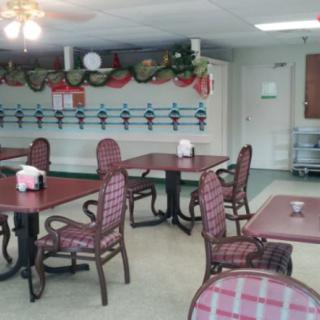A cozy dining area with tables and chairs, featuring festive decorations.