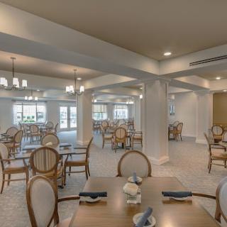 A spacious and elegantly designed dining area, featuring well-set tables and an inviting atmosphere.