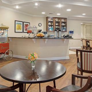 Cozy cafe interior with a seating area and counter, featuring a popcorn machine.
