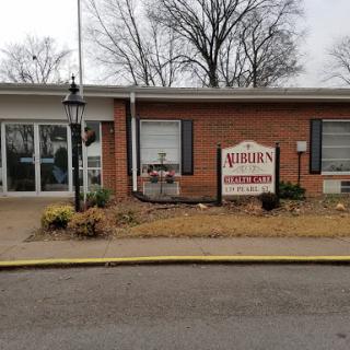 A view of a brick building with a prominent sign in front.
