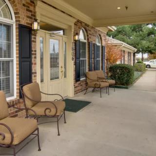 A cozy entrance with outdoor seating on a covered porch.