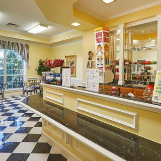 A cozy cafe interior featuring a checkered floor and a service counter with menu boards.