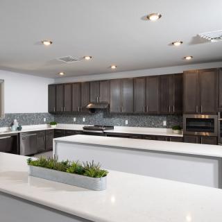 A modern kitchen with sleek countertops and dark wood cabinets.