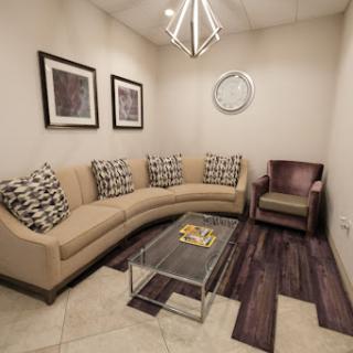 A cozy and modern living room area featuring a curved sofa, decorative cushions, and a stylish coffee table.