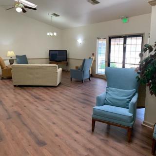 A cozy living room with comfortable seating, a television, and wooden flooring.