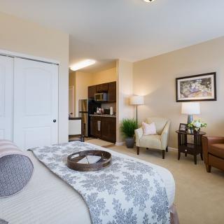 A cozy bedroom with a comfortable bed, stylish decor, and seating area.