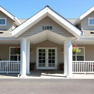 The front entrance of a building with large white columns and a covered porch.