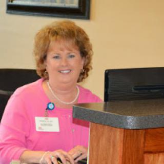 A friendly receptionist at her desk, ready to assist visitors.