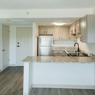 A modern kitchen in an apartment with stainless steel appliances and granite countertops.