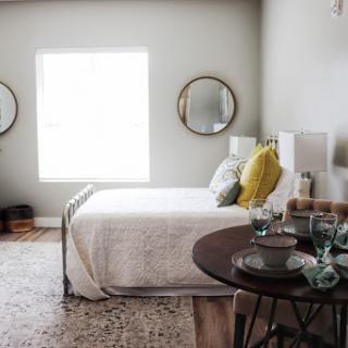 A beautifully designed modern bedroom featuring natural light, minimalist decor, and elegant furnishings.