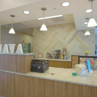 A modern reception desk area with overhead lighting.