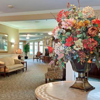 A beautifully decorated lobby with a large floral arrangement and comfortable seating.