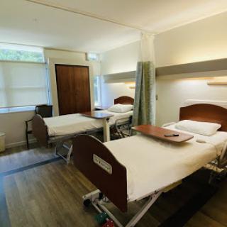 A clean and bright hospital patient room with two beds.
