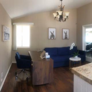 A cozy office space with a desk, chair, and sofa.