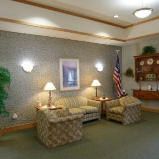 A cozy waiting room with comfortable chairs, lamps, and decorative elements.