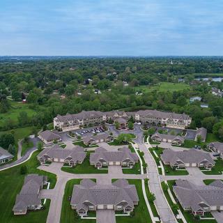 An aerial view of a suburban residential neighborhood surrounded by lush greenery.