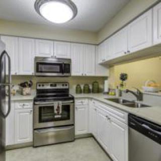 A modern kitchen with stainless steel appliances and white cabinetry.
