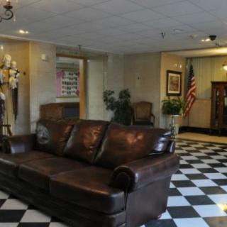 A cozy lobby area with a leather sofa and checkered flooring.