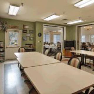 A communal meeting room with tables and chairs arranged for group activities.