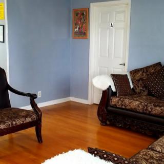 A cozy living room with blue walls, featuring elegant furniture and a hardwood floor.