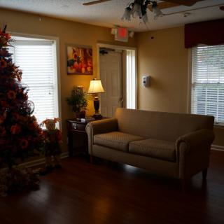A cozy living room decorated with a Christmas tree and a comfortable sofa.