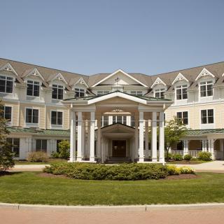 A symmetrical residential building with a landscaped front entrance.