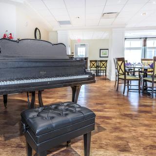 A spacious music room featuring a grand piano and comfortable seating arrangement.