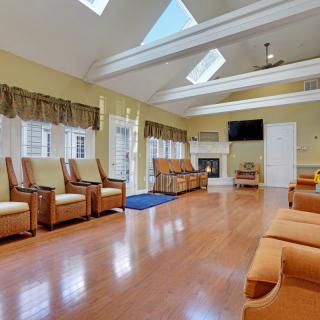 A spacious living room with skylights, wooden flooring, and comfortable seating.