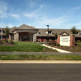 A modern healthcare facility with well-maintained landscaping under a clear blue sky.