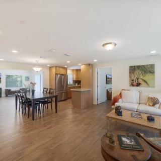 Spacious open floor plan with a modern living room, dining area, and kitchen featuring hardwood floors.