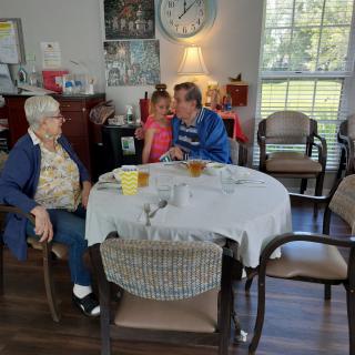 A family gathering around a dining table sharing a moment together.