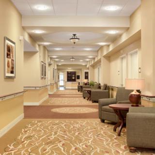 A well-lit, modern hallway featuring comfortable seating and decorative artwork.