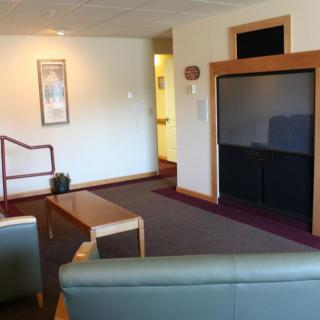 A modern living room with a large television, comfortable seating, and a minimalist design.
