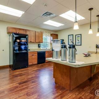 A modern kitchen with wooden cabinets, a center island, and sleek appliances.