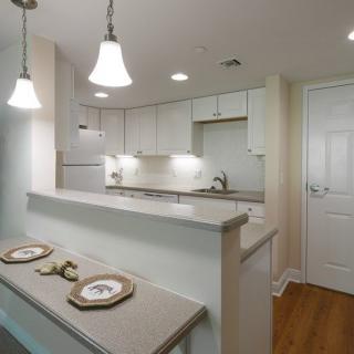 Modern kitchen with sleek countertops and pendant lighting.