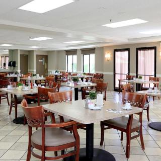 An empty dining area with neatly arranged tables and chairs in a modern setting.