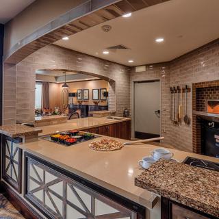 A modern kitchen setup with a pizza oven and preparation area.