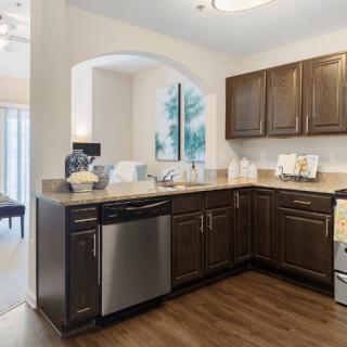 A modern kitchen featuring dark wood cabinets and stainless steel appliances.