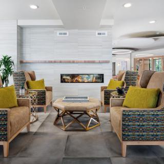 A modern living room with a cozy seating area centered around a stylish fireplace.