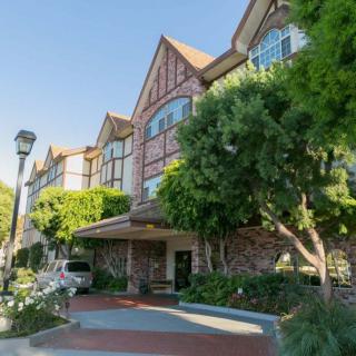 A charming hotel with Tudor-style architecture and lush greenery.