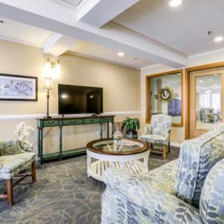 A cozy living room with patterned furniture, a television, and tasteful decor.