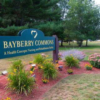 An outdoor sign for Bayberry Commons surrounded by well-maintained landscaping.
