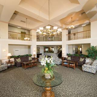 A spacious and elegantly designed hotel lobby featuring comfortable seating, a chandelier, and decorative plants.