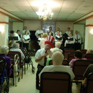 A choir performs in front of an audience seated indoors.