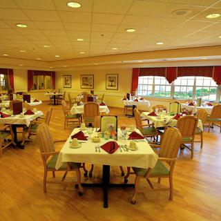 An elegant dining room with neatly arranged tables and chairs, ready for guests.