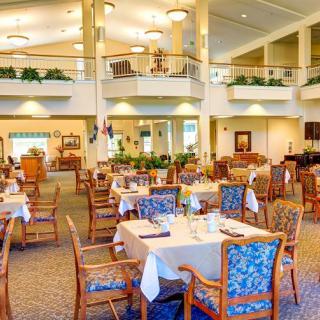 A spacious and elegantly decorated dining area with neatly arranged tables and chairs.