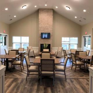 A spacious and modern dining area featuring tables, chairs, and a cozy fireplace.