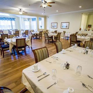 A spacious and elegantly arranged dining room with neatly set tables and chairs, ready for guests.